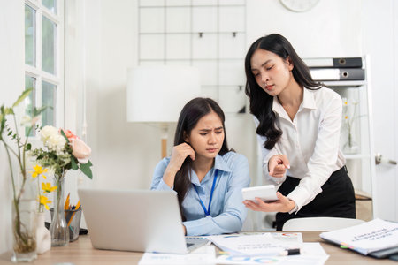Guiding Colleague Through Challenges. Businesswoman providing direction to her stressed colleague in the office.の写真素材
