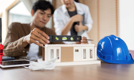 ESG in Architecture. Professionals collaborating on sustainable building design with a model.の写真素材