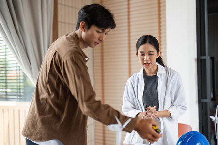 ESG Practices in Architecture. Young architects examining project plans and models.の写真素材