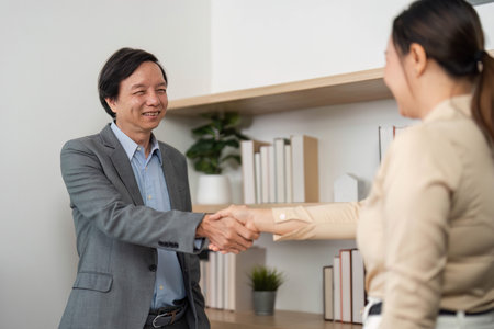 Professional Networking. Business partners shaking hands in a stylish office environment.の写真素材
