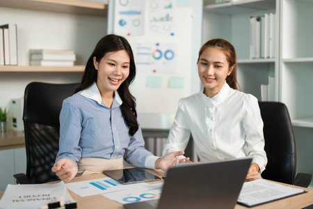 Business Presentation and Collaboration. Two women discussing data insights in a modern office.の写真素材