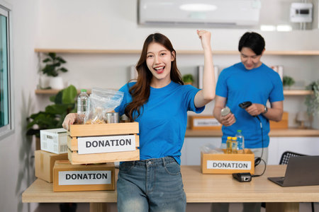 Donation Celebration. Volunteer expressing joy while holding a donation box.の写真素材