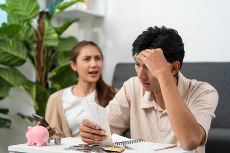 Financial Stress. Individual feeling overwhelmed while reviewing expenses with a partner.の写真素材