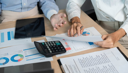 Team Collaboration and Financial Analysis. Professionals reviewing data and reports in a modern...