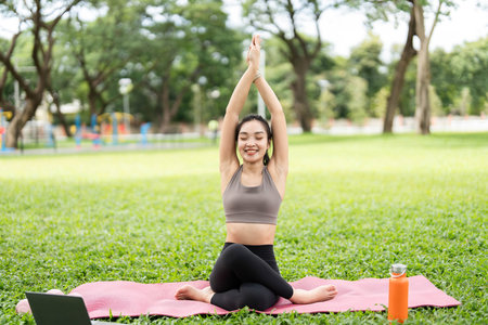 Yoga practice outdoors. Young woman performing yoga poses in a park.の写真素材