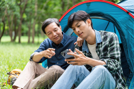 Family connection during camping. Father and son sharing moments inside a tent.の写真素材