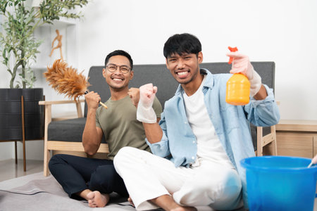 Cheerful LGBTQIA Couple Posing with Cleaning Supplies