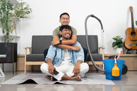 Happy Couple Embracing While Cleaning. Loving interaction during household chores.の写真素材