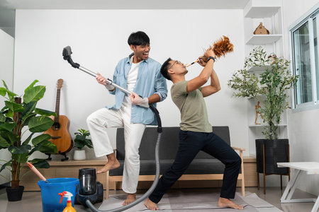 Energetic Cleaning Duo. Two friends having fun while cleaning their living room.の写真素材