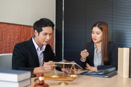 Legal Advice and Professional Interaction. A lawyer showing legal documents to a client in a modern office.の写真素材