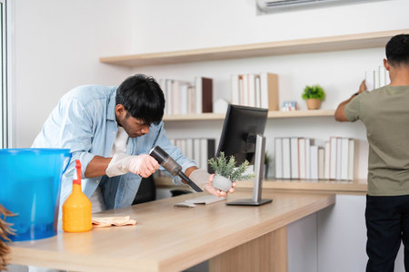Office Cleaning Team. Two young men collaborating to maintain a clean workspace.