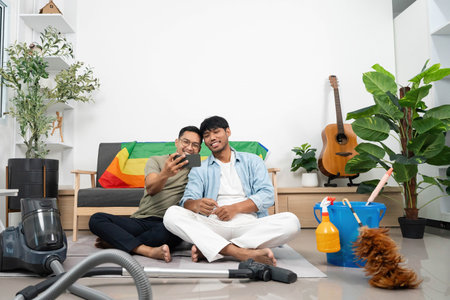 LGBTQIA Friendship and Connection. Two young men taking a selfie while enjoying their time at home.の写真素材