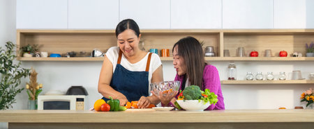 Healthy Cooking Together. Women enjoying vegetable preparation in a bright kitchen.の写真素材