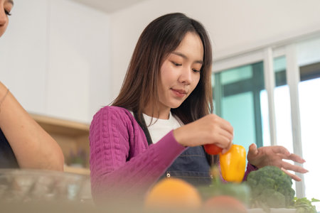 Healthy Cooking Together. Two women preparing fresh vegetables in a bright kitchen.の写真素材