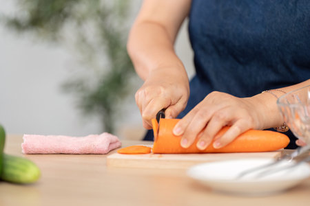 Healthy Cooking and Meal Prep. A close-up of hands slicing a carrot in a stylish kitchen.の写真素材