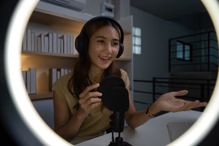 Engaging Online Presence. Young woman smiling while interacting with her audience through a microphone.の写真素材