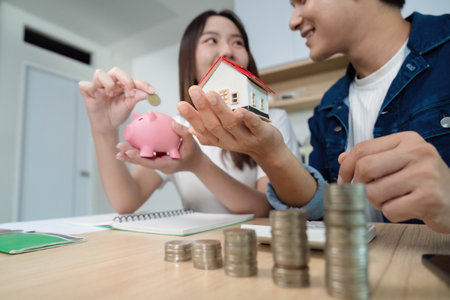 Couple Discussing Home Investment. Young partners planning finances with piggy bank and house.の写真素材