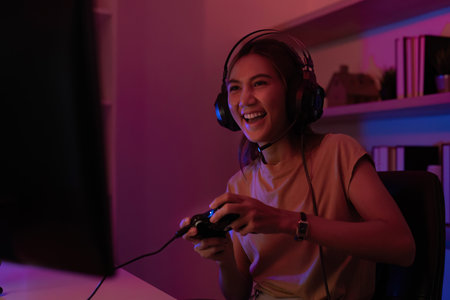 Gamer Enjoying Console Play. Young woman immersed in gaming at home.の写真素材