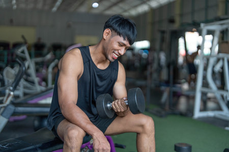 Weightlifting Exercise. Man lifting dumbbell in gym with focus.