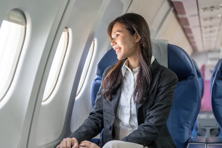 Business Travel. Young woman enjoying window view on airplane during flight.の写真素材