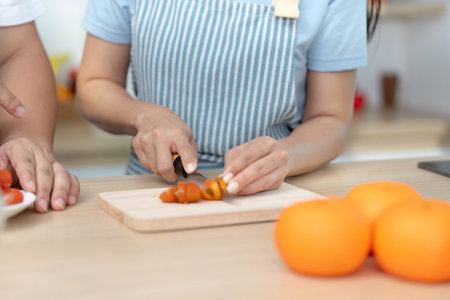Healthy Cooking: Woman slicing tomatoes in a bright kitchenの写真素材