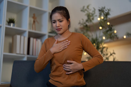 Health Awareness: Young woman experiencing abdominal pain while seated