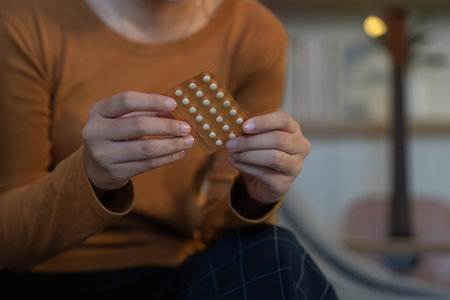 Medication Management. Woman holding blister pack of pills, focusing on health.の写真素材