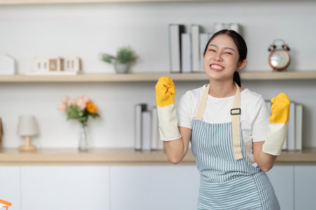 Excited for Cleaning. Young woman celebrating with rubber gloves and a smile.の写真素材