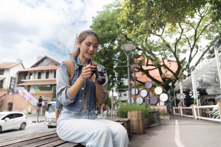 Enthusiastic photographer reviewing shots in cityの写真素材