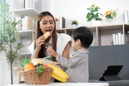 Healthy snack time. Mother and child enjoying fruits together.の写真素材
