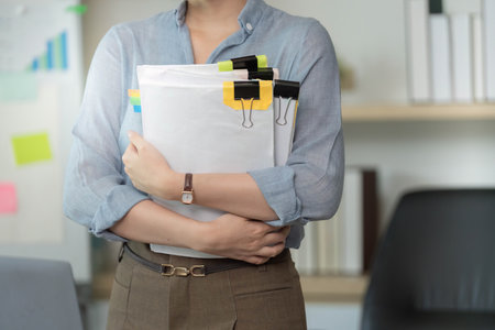 Organizational Skills. Businesswoman carrying documents in office.