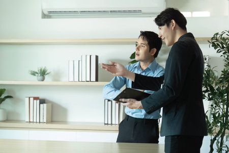 Client Consultation. Two businessmen discussing project details in a modern office.の写真素材