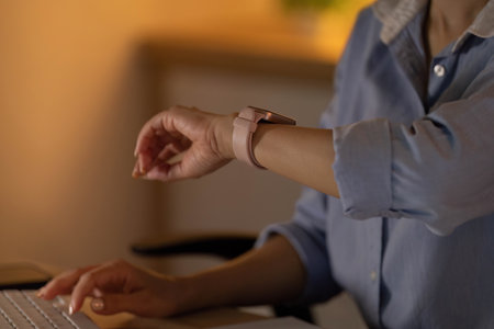 Smart Technology. Individual checking smartwatch while working.の写真素材