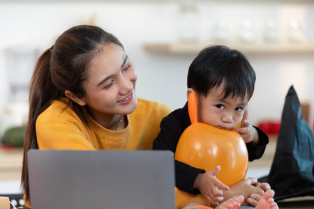 Halloween Fun. Mother and son sharing playful moments with balloons and smiles.の写真素材