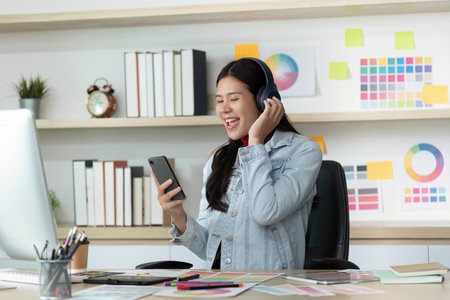 Happy Young Woman Enjoying Music While Working on Smartphone