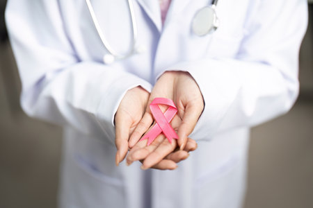 Breast Cancer Awareness. Doctor holding pink ribbon in hands, symbolizing hope.の写真素材