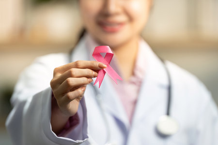 Breast Cancer Awareness. Doctor holding pink ribbon with a smile.の写真素材