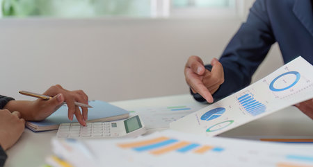 Financial Consultation. Professionals discussing budget charts and graphs in a collaborative setting.の写真素材