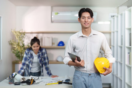 Engineer collaborating on construction project with plans and tools