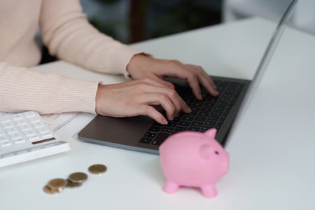 Financial Management. Typing on a laptop while managing savings.の写真素材