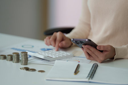 Financial Planning. Using a smartphone and calculator for budgeting.の写真素材