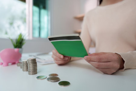 Financial Management. Reviewing savings with coins and a notebook.の写真素材