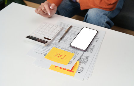 Tax preparation. Individual calculating taxes with documents and calculator at home.