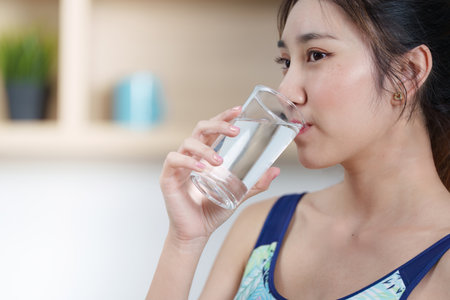 Hydration. Woman drinking water, emphasizing importance of hydration in wellness.の写真素材