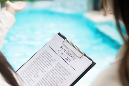 Real Estate Contract. Close-up of a contract document by a poolside.の写真素材