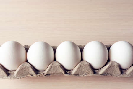 five white eggs in a cardboard boxの写真素材