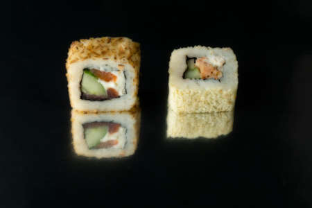 blured two maki with tuna on black background