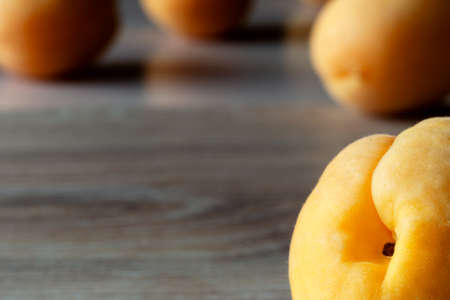 four apricots in backlight on a wooden background.の写真素材