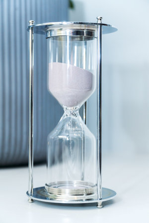 hourglass with soft pink sand  background