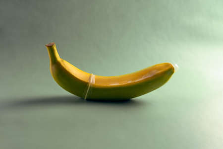 banana in a condom on a light gray backgroundの写真素材